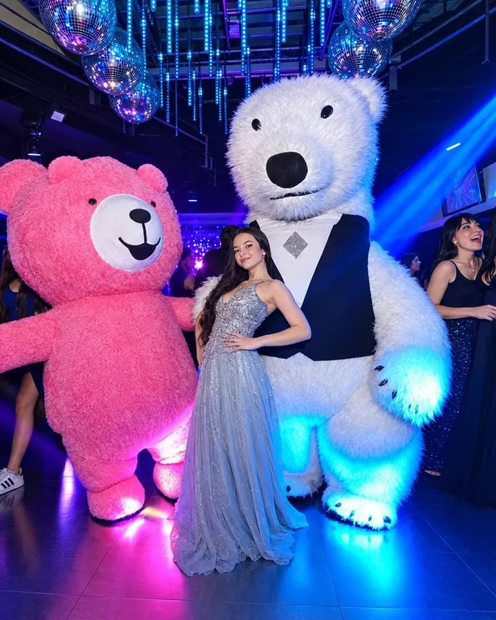 Oso rosa y oso polar gigantes con una quinceañera en la pista