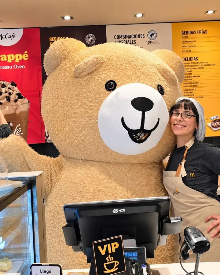 Oso gigante con una empleada de McCafé