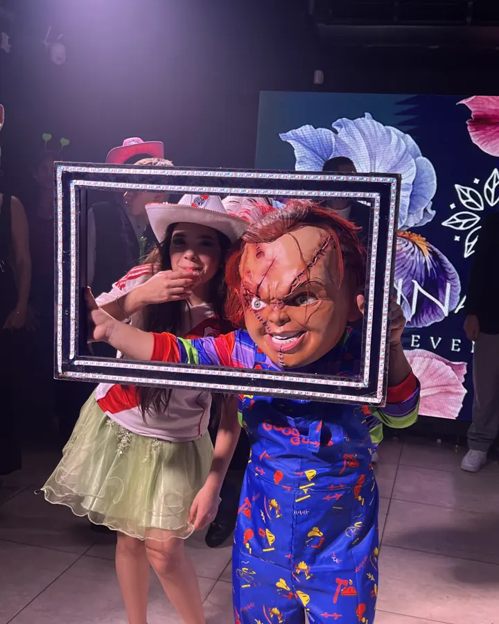 Personaje de terror con un marco de fotos en una fiesta